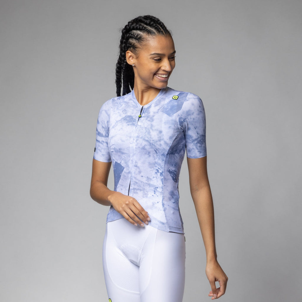 Woman wearing Alé Marble women's cycling jersey in light blue marble print with white bib shorts, front view
